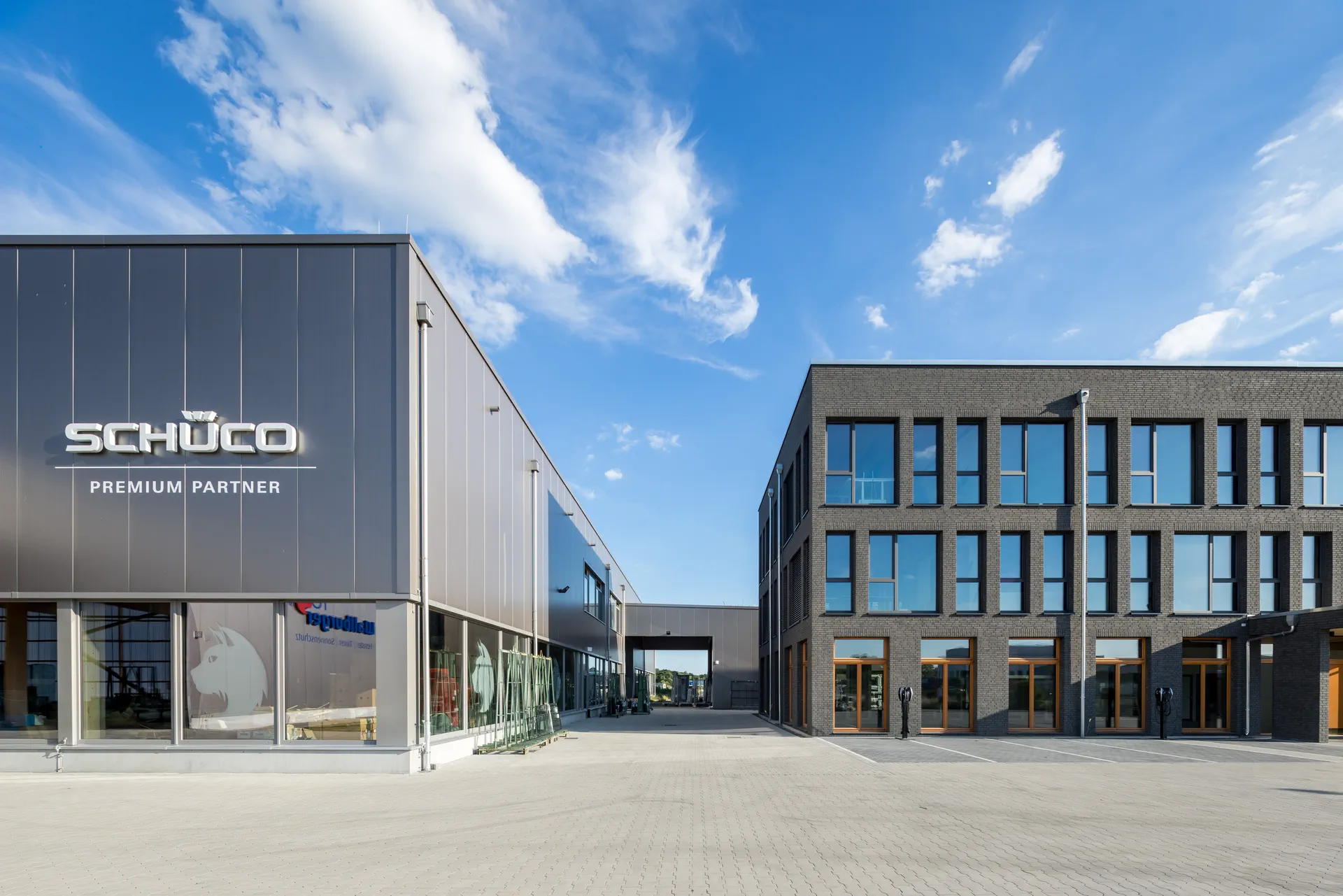 Timber office building with a dark façade beside an X-Wood® hall