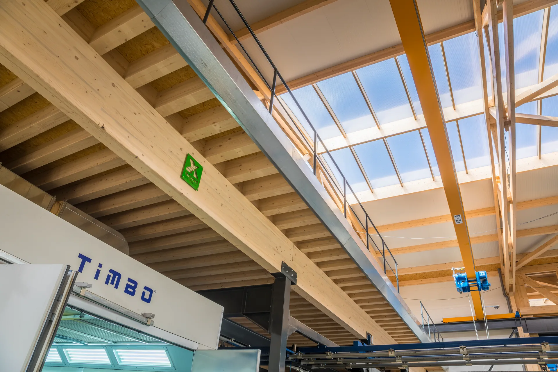 Intérieur lumineux d’une halle X-Wood® au plafond en bois apparent