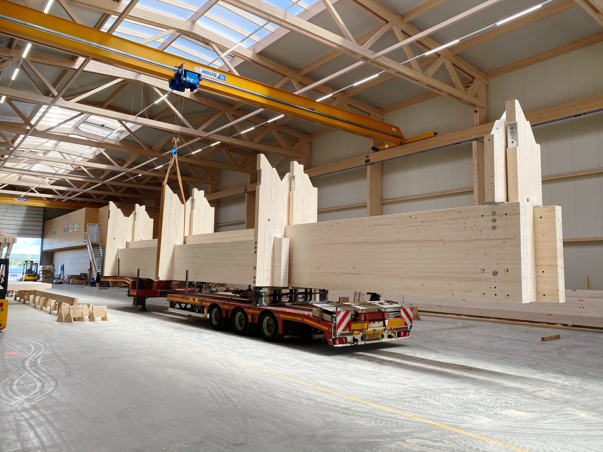 Vorgefertigte Brettschichtholz-Binder auf dem Tieflader in der X-Wood®-Produktionshalle