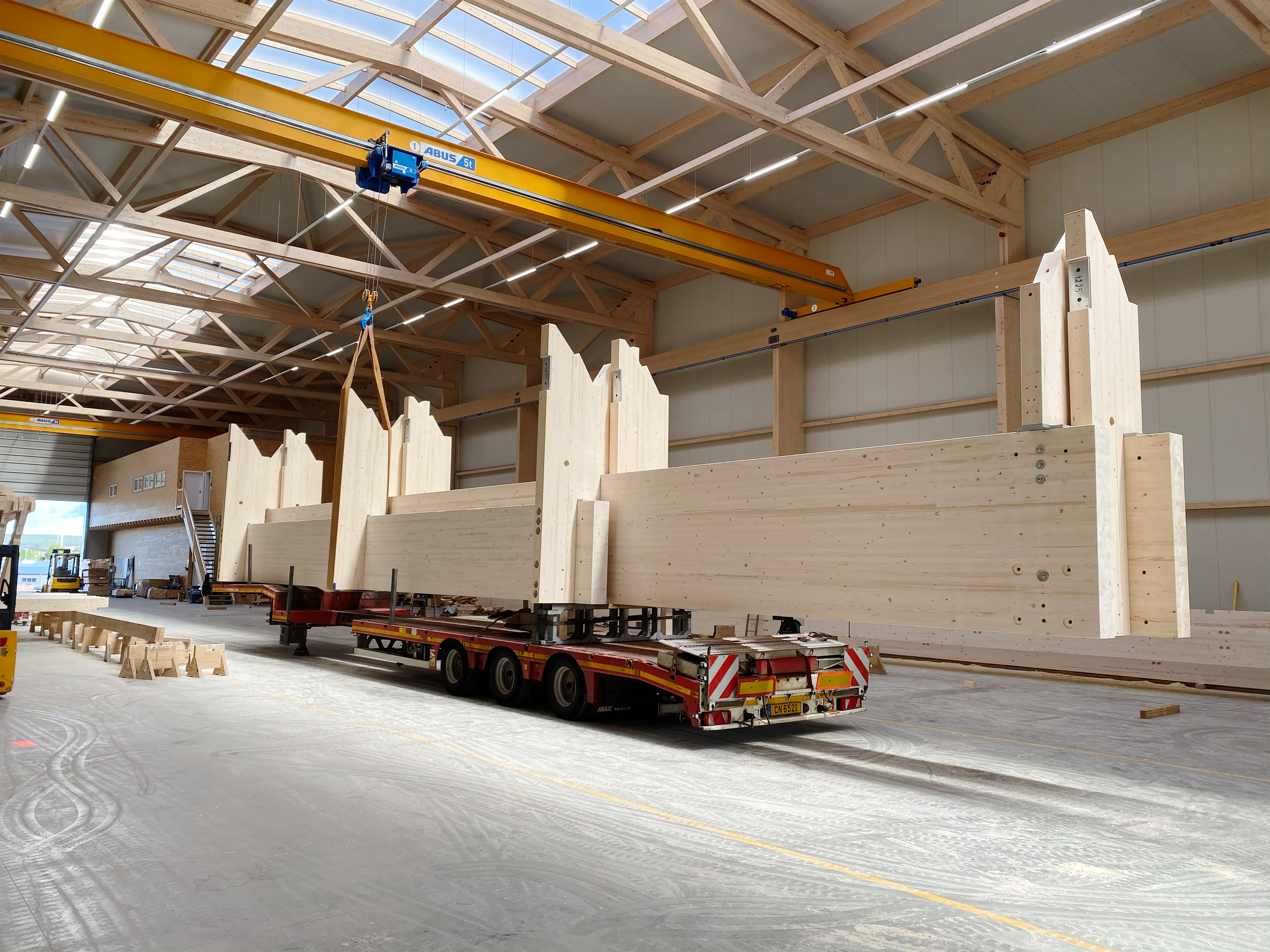 Vorgefertigte Brettschichtholz-Binder auf dem Tieflader in der X-Wood®-Produktionshalle