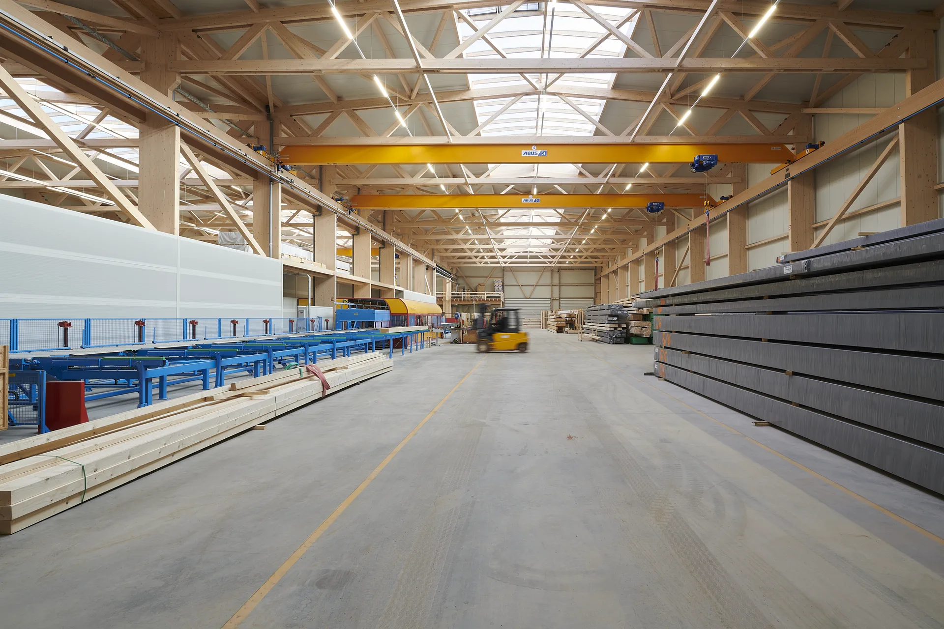 Blick in eine Holzhalle von X-Wood® mit sichtbarer Dachkonstruktion aus Holz