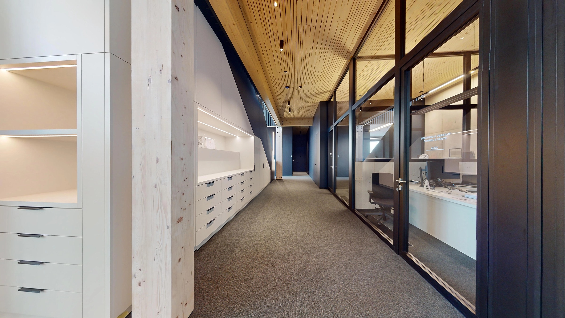 Bürogang in einer X-Wood®-Halle mit Holzdecke und verglasten Besprechungsräumen