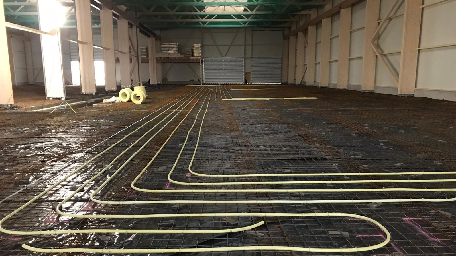 Verlegung einer Flächenheizung in einer Hallenbodenplatte vor dem Betonieren