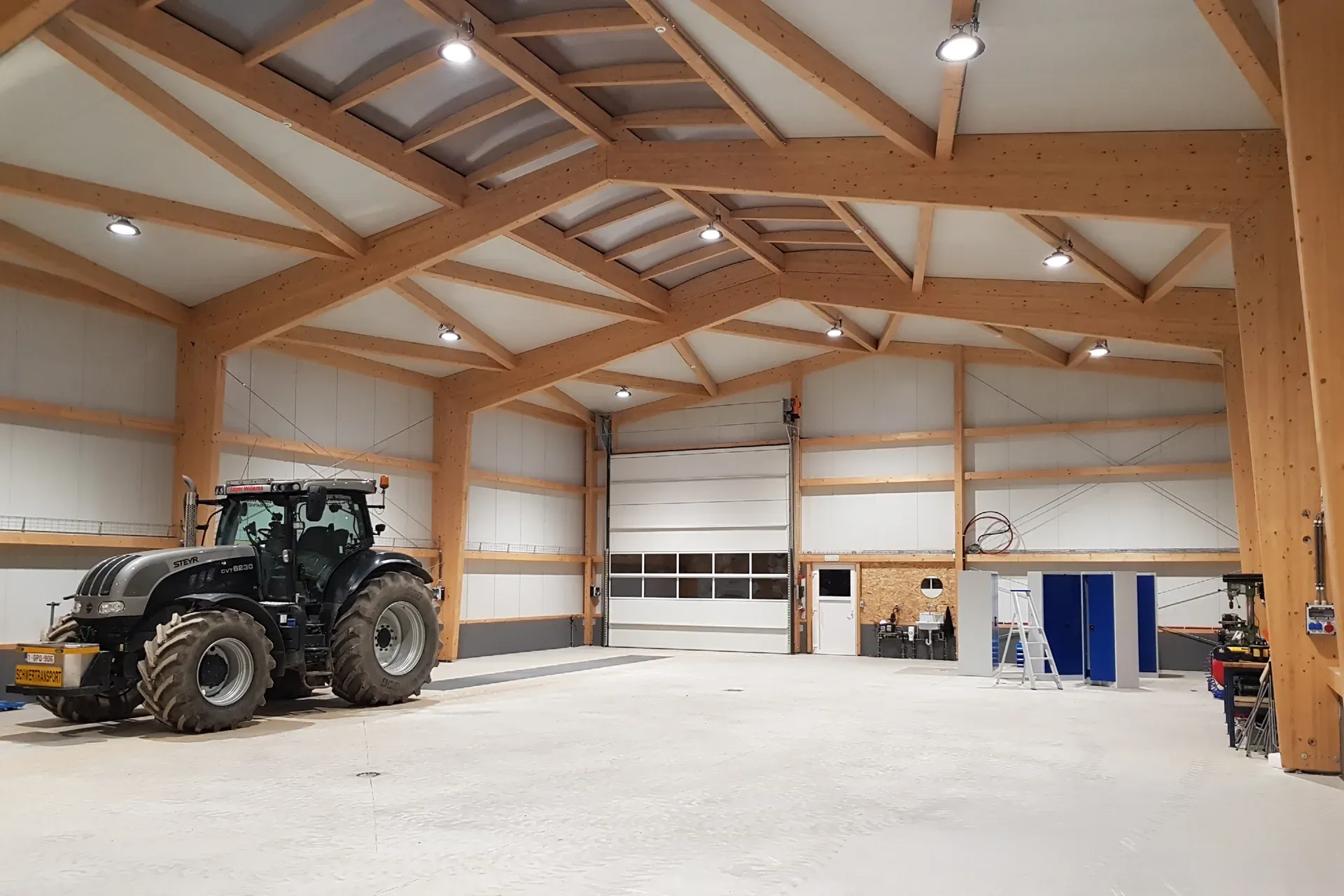 The Edgar Willems machinery hall in Heppenbach with a tractor, a tall timber structure and sectional doors on the gable end.