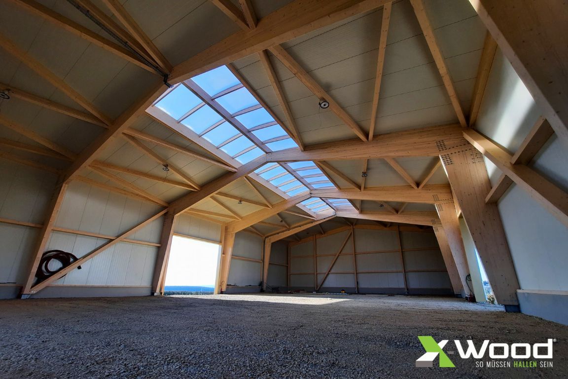 Interior view of a timber hall with a ridge light and an exposed load-bearing structure
